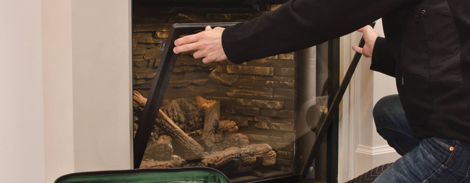 man putting in screen in gas fireplace