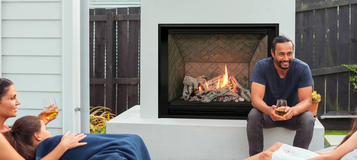 family sitting around outdoor fireplace